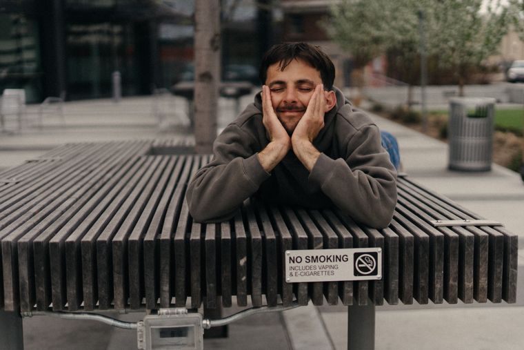 Trace Keller resting his face in his hands on a bench