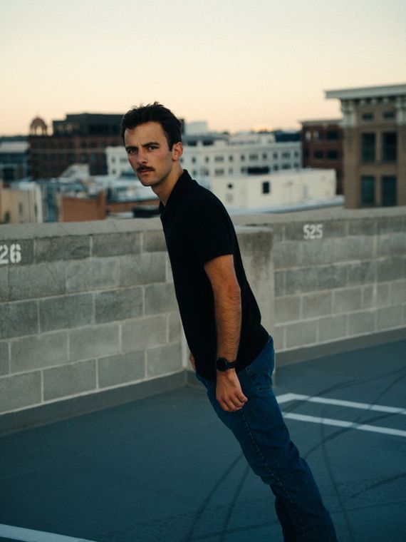 Trace Keller leaning toward the camera on a Boise rooftop