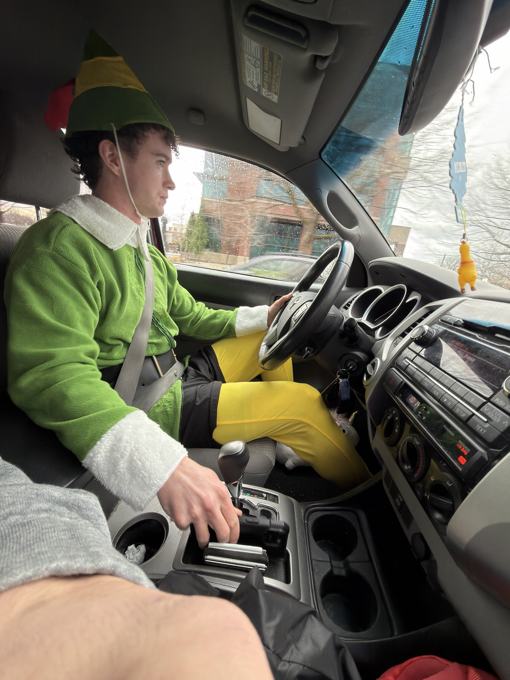 Man in an elf costume driving a truck