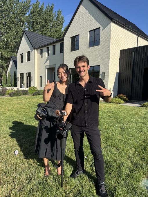 Trace Keller and a fellow creative on a sunny lawn with camera gear