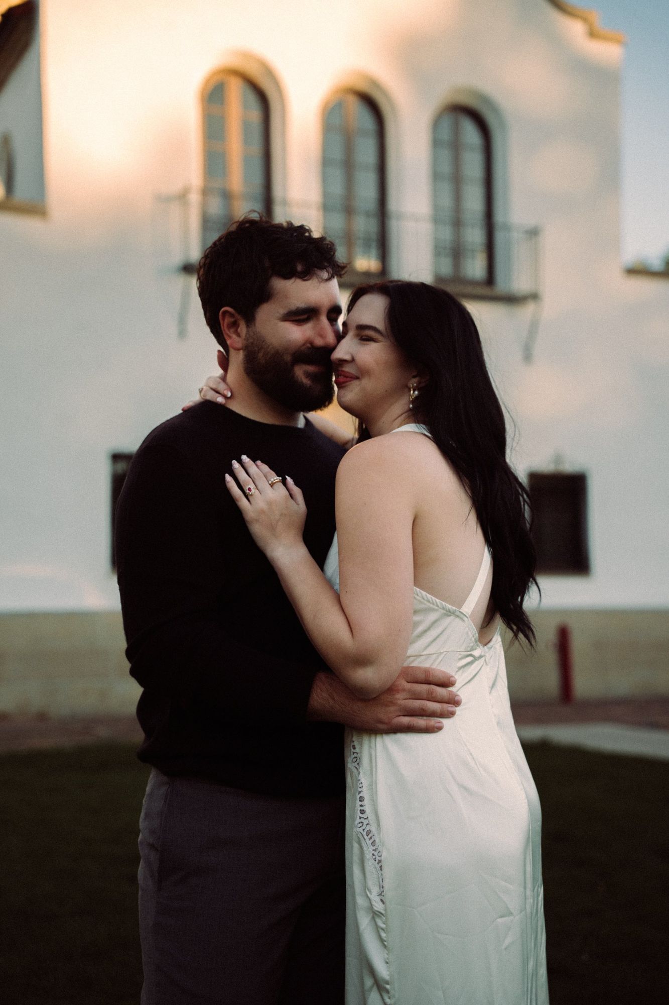 James and Cora hugging in front of the arched windows of the Boise Depot, glowing in golden light