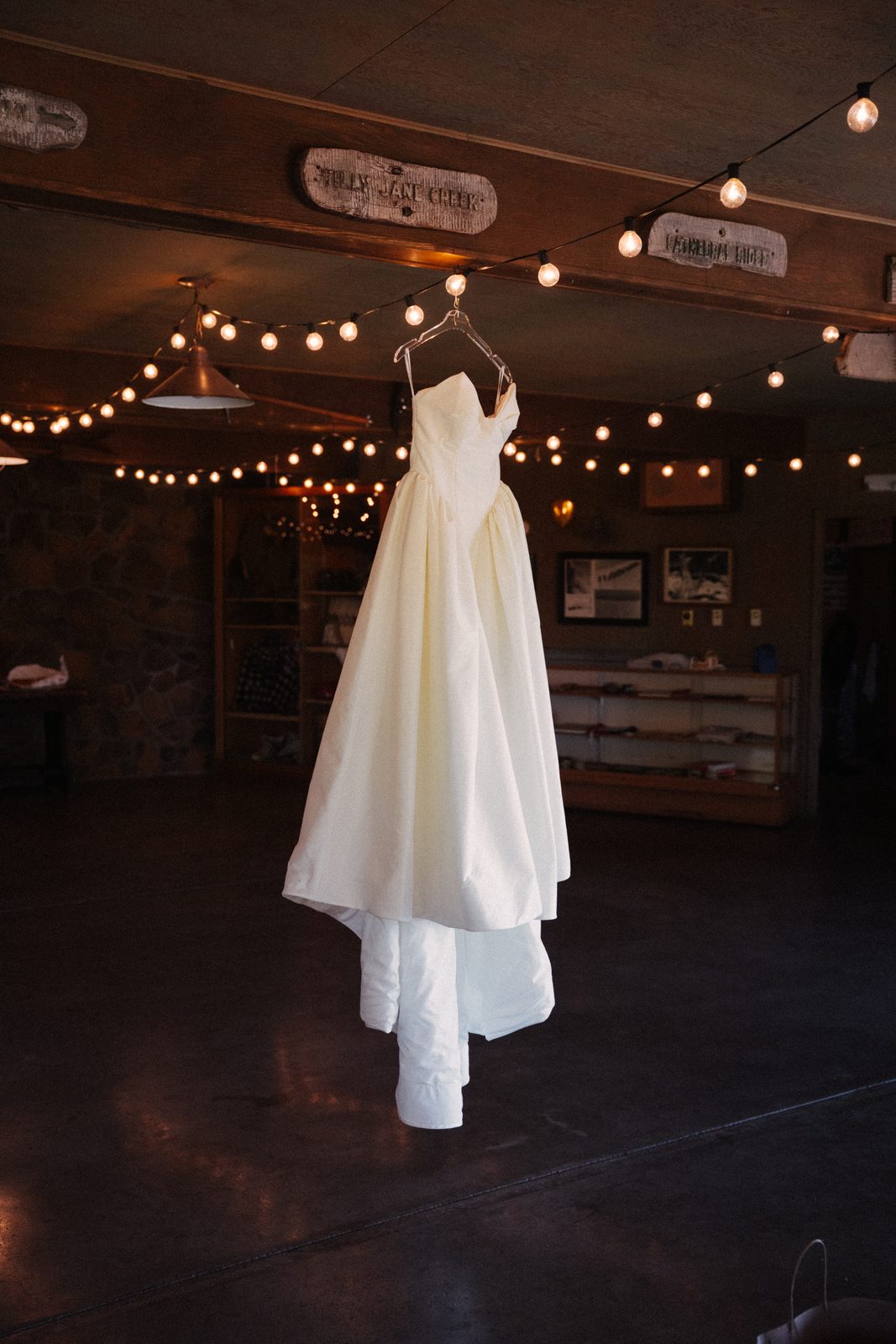 Wedding dress hanging from string lights inside the Crag Rat Hut